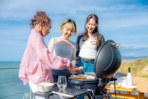 een groep van drie vrouwen die eten bereiden op een grill bij the SHIHACHI 
