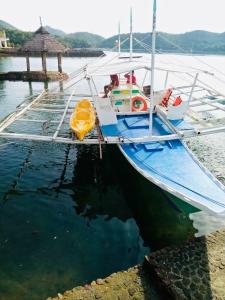 Un barco está atracado en el agua con una balsa amarilla. en Stunning luxe 220sm villa by the sea entirely private with own pool, en Busuanga