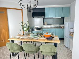 a kitchen with blue cabinets and a wooden table with chairs at 一棟貸切りNagoya west2 in Nishi-biwajima