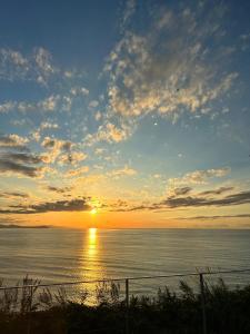 een zonsondergang boven een waterlichaam met een hek bij the SHIHACHI  +83 foto's