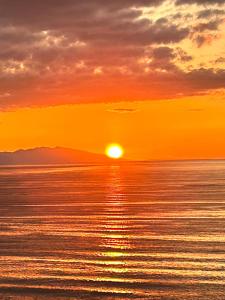 een zonsondergang boven de oceaan met zonsondergang bij the SHIHACHI 