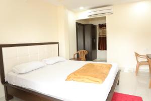 Un dormitorio con una cama blanca con una manta. en SV Grand, en Proddatūr 9 fotos más