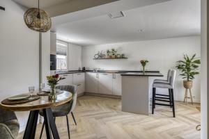 Una cocina y un comedor con mesa y sillas. en Cosy Nest, en Noordwijk aan Zee