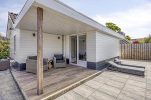 Una casa con una terraza con una silla encima. en Cosy Nest, en Noordwijk aan Zee