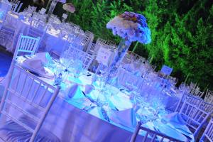 una mesa larga con sillas blancas y un jarrón con flores en Monteverde Hotel, en Beit Meri
