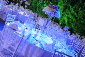 a long table with white chairs and a vase with flowers at Monteverde Hotel in Beit Meri