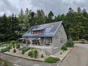 a house with solar panels on top of it at Apartmány Obora in Nová Bystřice