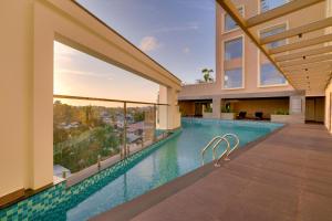 an indoor swimming pool with a view of a building at Lemon Tree Premier, Thiruvananthapuram in Trivandrum
