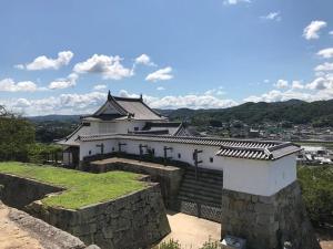 a building on top of a stone wall at Hotel Sun tsuyama in Tuyama