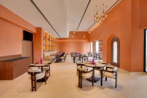 a restaurant with tables and chairs in a room at Lemon Tree Premier, Thiruvananthapuram in Trivandrum