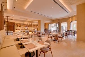 a restaurant with tables and chairs in a room at Lemon Tree Premier, Thiruvananthapuram in Trivandrum