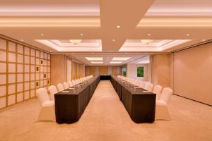 a conference room with a long table and white chairs at Lemon Tree Premier, Thiruvananthapuram in Trivandrum +69 photos