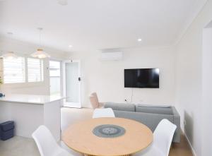 a living room with a table and a couch at Haven at Redcliffe - your stay on the Peninsula in Redcliffe +5 photos