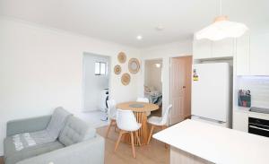 a kitchen and living room with a couch and a table at Haven at Redcliffe - your stay on the Peninsula in Redcliffe