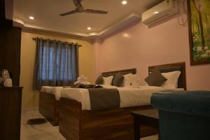 a bedroom with a large bed with a ceiling fan at Hotel Plaza in Chunchura +3 photos