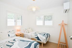 a bedroom with two beds and two windows at Haven at Redcliffe - your stay on the Peninsula in Redcliffe