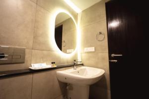 a bathroom with a sink and a mirror at SinQ Village in Bambolim +7 photos