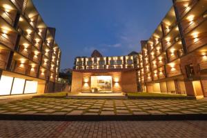 a large building with a courtyard at night at SinQ Village in Bambolim