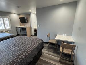 Una cama o camas en una habitación de Bronco Motel South Central