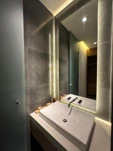 een badkamer met een witte wastafel en een spiegel bij Jaladhi Echo Beach Villa in Canggu