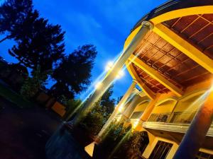 a yellow building with a sun shining on it at KERESI BLOCK At PENIEL BEACH HOTEL in Entebbe