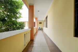 an empty hallway in a school building with plants at Hotel O Griya Cewang Syariah in Bekasi +31 photos