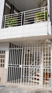 カリにあるHermosa casa en caliの建物の側面にある白い金属製の門