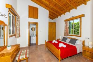 a bedroom with a red bed and a bathroom at Villa Ibiscus by Villa Plus in Polis Chrysochous +38 photos