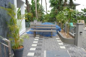 a wooden bench sitting on a patio with plants at Joen homes apartment in Alwaye