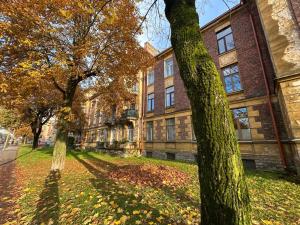 een oud bakstenen gebouw met bomen ervoor bij Apartment Kopli 78 in Tallinn