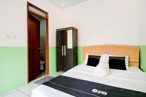 a bedroom with a large bed and a bathroom at Hotel O Griya Cewang Syariah in Bekasi