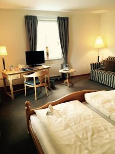 um quarto de hotel com uma cama e uma secretária com um computador em Bärenkrug em Molfsee