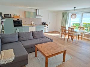 ein Wohnzimmer und eine Küche mit einer Couch und einem Tisch in der Unterkunft Ferienwohnung Luise unterhalb der Burg Lindenfels in Lindenfels