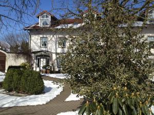 a white house with snow on the ground at Bärenkrug in Molfsee