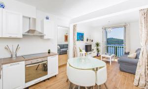 a kitchen and living room with a table and a couch at Apartment Majestic in Dubrovnik
