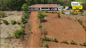 an aerial view of a house in a field at Devraai Homestay 