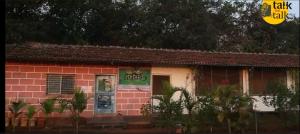 a small red brick building with a sign on it at Devraai Homestay  +3 photos