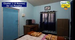 a room with two beds and a desk and a window at Devraai Homestay 