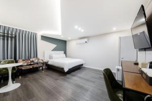 een hotelkamer met een bed en een tv bij Jeonju Summit Stay in Jeonju