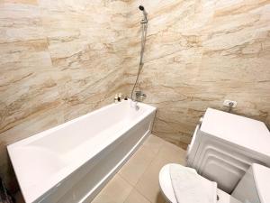 een badkamer met een wit bad en een toilet bij Central Address Studio 16 in Boekarest +8 foto's