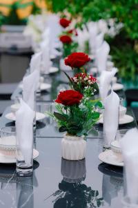 a long table with red roses in a vase on it at Kangaroo homestay in Cat Ba +46 photos