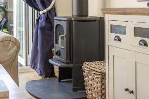 a black stove in a kitchen with a couch at Shore View - East Wittering in East Wittering
