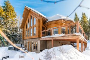a large wooden house in the snow at Fiddler Lake Resort - Deer 90 in Mille-Isles