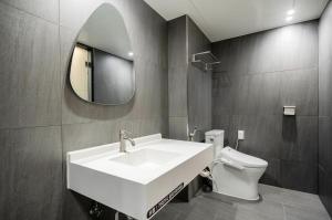 een badkamer met een wastafel, een toilet en een spiegel bij Jeonju Summit Stay in Jeonju +35 foto's
