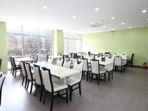 a dining room with white tables and chairs at Sea View Hotel in Naedo-dong
