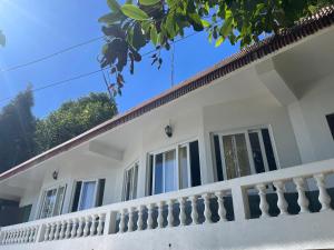 a white house with a balcony at Lemos Cafe and Homestay in Kurseong +11 photos