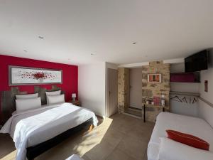 a bedroom with two beds and a red wall at Au Petit Bignon in Les Épesses +39 photos