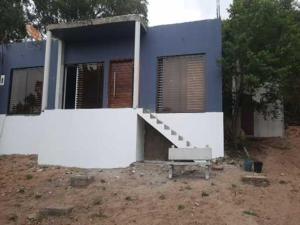 una casa blu e bianca con una panchina davanti di Ponta Family holiday house a Ponta do Ouro