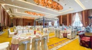 een feestzaal met witte tafels en witte stoelen bij Zhangjiagang Jiangnan Garden Hotel in Xiwujieqiao