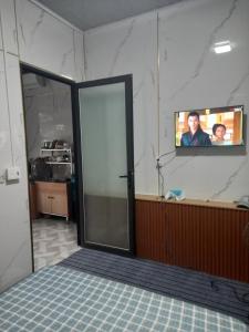 a room with a sliding glass door with a tv on the wall at Mai homestay in Mỹ Lại (5)